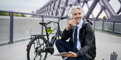 Mann mit Fahrrad vor Brücke